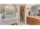 Bathroom with soaking tub, tile floors, and a double-sink vanity at 141 Prestwick Dr, Davenport, FL 33897