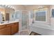 Well-lit bathroom with a shower, soaking tub, and wood vanity with sink at 141 Prestwick Dr, Davenport, FL 33897