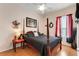 Bedroom featuring a four poster bed, wood floors, and red accents for a cozy space at 141 Prestwick Dr, Davenport, FL 33897