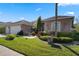 Charming single-story home with a manicured front lawn, mature landscaping, and decorative accents at 141 Prestwick Dr, Davenport, FL 33897