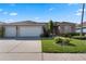 Charming single-story home featuring a spacious three-car garage, lush lawn, and beautiful landscaping at 141 Prestwick Dr, Davenport, FL 33897