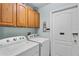 Laundry room includes washer, dryer and upper wood cabinets at 141 Prestwick Dr, Davenport, FL 33897