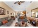 Open concept living room with neutral tones, tile flooring, ceiling fan, and view of the kitchen at 141 Prestwick Dr, Davenport, FL 33897