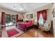 Spacious main bedroom with dark wood floors, red bedding, and sliding glass doors to the pool area at 141 Prestwick Dr, Davenport, FL 33897