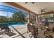 Covered patio with chairs and tables overlooking the pool and jacuzzi at 141 Prestwick Dr, Davenport, FL 33897