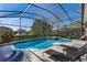 A screened pool with a hot tub and an outdoor seating area with chaise lounges at 141 Prestwick Dr, Davenport, FL 33897