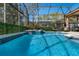 A screened pool with an adjoined hot tub and an outdoor seating area at 141 Prestwick Dr, Davenport, FL 33897