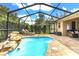 Screened in pool with waterfall feature, lush landscaping, and outdoor seating at 151 Lake Arietta Ct, Auburndale, FL 33823