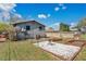 Rear view of home with a gravel fire pit area, grass, trees, an AC Unit and a privacy fence at 1623 Montana Ave, St Cloud, FL 34769