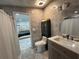 Stylish bathroom featuring marble tile, modern fixtures, vanity and cabinets, seamlessly flowing into the adjacent bedroom at 18633 14Th Ave, Orlando, FL 32833