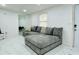 Comfortable living room featuring white marble floors and a gray sectional sofa with decorative pillows at 18633 14Th Ave, Orlando, FL 32833