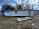 View of the shed in the backyard, including a white door, window, and concrete slab, great for storage space at 18633 14Th Ave, Orlando, FL 32833