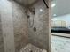 Modern shower featuring marble tile surround, and stylish fixtures, flowing into the adjacent bedroom at 18633 14Th Ave, Orlando, FL 32833