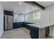 Modern kitchen features navy cabinets, stainless appliances and a breakfast bar with white countertop at 2061 S Peninsula Dr, Daytona Beach, FL 32118