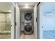 Convenient laundry closet featuring a stacked washer and dryer and nearby access to a shower at 2061 S Peninsula Dr, Daytona Beach, FL 32118