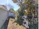 Side yard features a white fence, foliage and a sun-drenched lawn at 250 Sir Phillips Dr, Davenport, FL 33837