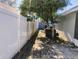 Side yard with pavers, privacy fence, and a tree with filtered sunlight at 250 Sir Phillips Dr, Davenport, FL 33837