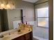 Bathroom featuring a double sink vanity, framed mirror, and a soaking tub at 250 Sir Phillips Dr, Davenport, FL 33837