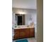 Bathroom with a double sink vanity, framed mirror, and a door leading to the main bedroom at 250 Sir Phillips Dr, Davenport, FL 33837