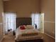 Cozy bedroom with neutral tones, a tufted headboard, and bright, patterned curtains creating a relaxing atmosphere at 250 Sir Phillips Dr, Davenport, FL 33837