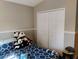 A cozy bedroom with a navy blue bedspread and a stuffed panda collection creates a playful and inviting atmosphere at 250 Sir Phillips Dr, Davenport, FL 33837