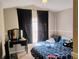 Bright bedroom featuring a blue patterned comforter, black curtains, and vanity at 250 Sir Phillips Dr, Davenport, FL 33837