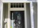 Close up of front door featuring decorative leaded glass and sidelight framed in white trim at 250 Sir Phillips Dr, Davenport, FL 33837