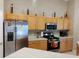 Kitchen with stainless steel appliances, wooden cabinetry, and plentiful counter space at 250 Sir Phillips Dr, Davenport, FL 33837