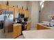 Kitchen featuring stainless steel appliances, wooden cabinetry, and adjacent breakfast bar at 250 Sir Phillips Dr, Davenport, FL 33837