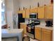 Kitchen featuring stainless steel appliances, wooden cabinetry, and a bright, airy atmosphere at 250 Sir Phillips Dr, Davenport, FL 33837