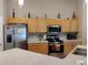 Kitchen with stainless steel appliances, wooden cabinetry, and plentiful counter space at 250 Sir Phillips Dr, Davenport, FL 33837