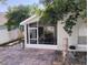 The outdoor brick patio leads to a white screened enclosure for outdoor dining and entertainment at 250 Sir Phillips Dr, Davenport, FL 33837