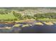 An aerial view of a lake with a long pier and dock, surrounded by community housing and lush greenery at 2884 Nottel Dr, St Cloud, FL 34772