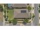 This aerial view showcases a well-maintained home with a solar panel roof, green yard, and neighborhood streets at 2884 Nottel Dr, St Cloud, FL 34772
