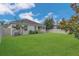 Lush backyard with a white fence, mature trees, and manicured lawn at 2884 Nottel Dr, St Cloud, FL 34772