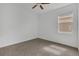 A bright bedroom features a ceiling fan, neutral carpet and walls, and a window with blinds at 2884 Nottel Dr, St Cloud, FL 34772