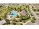 Aerial view showcasing a community pool area with a splash pad, lounge chairs, and shaded seating spaces at 2884 Nottel Dr, St Cloud, FL 34772