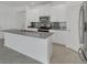 Modern kitchen featuring white cabinetry, a stainless steel appliance suite, and an eat-in kitchen island at 2884 Nottel Dr, St Cloud, FL 34772