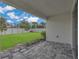 Covered patio with stylish pavers, overlooks a well-manicured backyard with a white fence at 2884 Nottel Dr, St Cloud, FL 34772