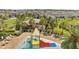 A community splash pad with colorful features and seating surrounded by palm trees at 2884 Nottel Dr, St Cloud, FL 34772