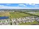 Scenic aerial view of a residential community, with a pond and green fields creating a serene backdrop at 293 Pineywoods St, St Cloud, FL 34772