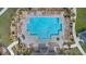 Aerial view of a sparkling community pool surrounded by lounge chairs and lush landscaping for relaxation at 293 Pineywoods St, St Cloud, FL 34772