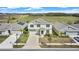 A beautiful aerial view of a two-story home with a lush green field backdrop and solar panels in neighborhood at 293 Pineywoods St, St Cloud, FL 34772