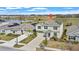 An aerial view shows a two-story home with solar panels and landscaping near a lake and lush green fields at 293 Pineywoods St, St Cloud, FL 34772