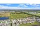 Scenic aerial view of a residential community, with a pond and green fields creating a serene backdrop at 293 Pineywoods St, St Cloud, FL 34772