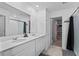Bright bathroom with double vanity, a large mirror, and a walk-in shower at 293 Pineywoods St, St Cloud, FL 34772