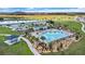 This aerial view shows the community pool, with a picnic area, playground, and nearby lake for recreation at 293 Pineywoods St, St Cloud, FL 34772