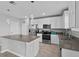 Bright kitchen featuring white cabinetry, stainless steel appliances, a center island, and modern pendant lighting at 293 Pineywoods St, St Cloud, FL 34772