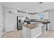 Well-lit kitchen with white cabinets, stainless steel appliances, an island, and modern lighting fixtures at 293 Pineywoods St, St Cloud, FL 34772