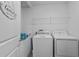Functional laundry room with a washer, dryer, and storage shelving at 293 Pineywoods St, St Cloud, FL 34772